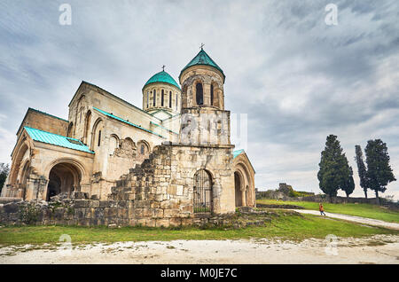 Femme marche à la chapelle de la tour de l'église Bagrati à ciel couvert à Kutaisi, Géorgie Banque D'Images
