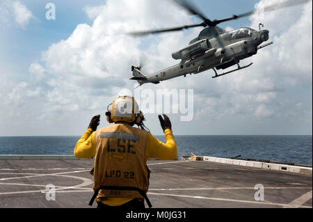 Maître de Manœuvre de l'aviation (manutention) Airman Anthony Similton dirige un AH-1Z Viper, hélicoptère d'attaque attribuée à rotors basculants moyen maritime (VMM) de l'Escadron 161 (renforcée), dans le poste de pilotage de la station de transport amphibie USS San Diego (LPD 22). Banque D'Images