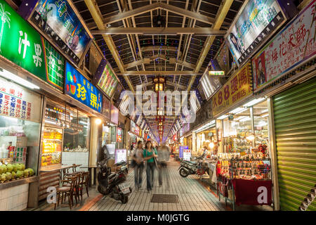 Les panneaux d'éclairage sans fin et les gens la nuit shopping dans la rue du Marché de nuit de Huaxi touristiques, Wanhua District, Taipei, Taiwan Banque D'Images