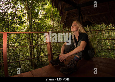 Une femme blonde se détend sur le balcon d'un ecolodge. Banque D'Images