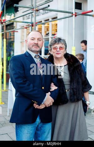 Couple mature habillé posant pour un portrait - homme et femme âgés, dans leur dimanche meilleur prêt à dîner, en face du bâtiment. Banque D'Images