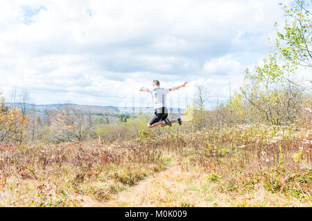 Les jeunes de l'athlétisme, monter, heureux homme qui court saut de jogging à l'automne, l'automne, l'été, randonnée chemin meadow field dans l'air, les muscles Banque D'Images