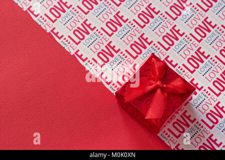 Valentines Day rouge fond gify fort avec le ruban rouge et le lettrage Love Banque D'Images