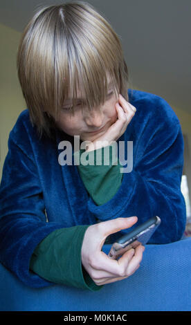 Jeune adolescent using mobile phone Banque D'Images