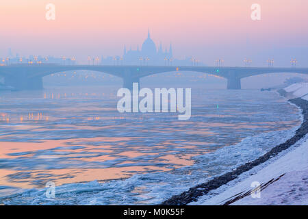 Danube couverte de plaques de glace, le pont, le Parlement aperçu dans la brume sèche Banque D'Images