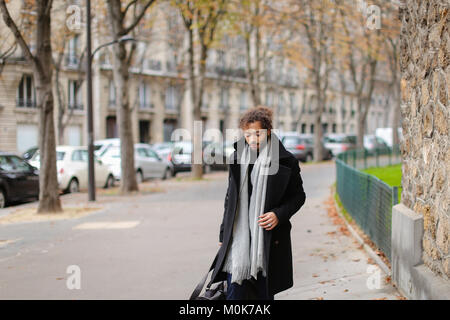 Guy mulâtre attrayant de quitter la ville et aller à la gare. Bel homme en manteau noir paraît attrayante. Concept de la marche, de se dépêcher et de l'automne Banque D'Images