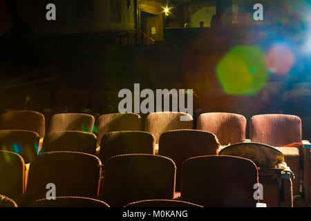 Chaises brisées dans un vieux théâtre abandonné avec la lumière du soleil qui brille sur le côté ; California, United States of America Banque D'Images