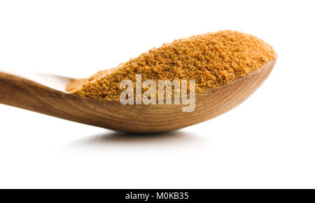 Le sucre de noix de coco sucrée dans spoon isolé sur fond blanc. Banque D'Images