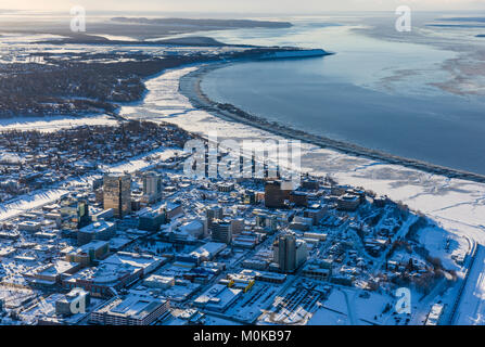 Vue aérienne de la neige couvrant le centre-ville d'Anchorage et Cook Inlet à marée basse, l'Hôtel Captain Hook et Conoco Philips bâtiments en premier plan, ... Banque D'Images