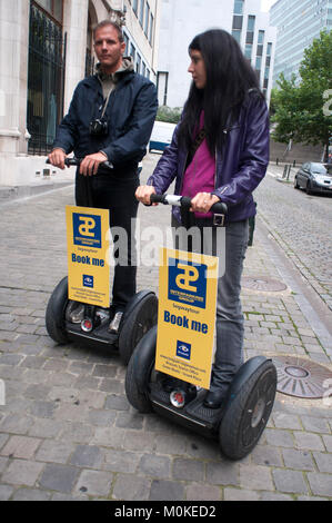 Un couple de touristes avec un segway location de l'autre côté de la rue à Bruxelles, Belgique. Banque D'Images