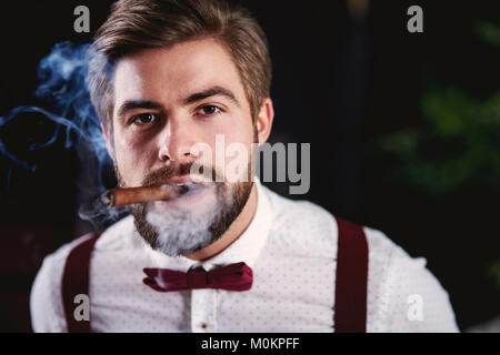 Vue avant du bel homme fumeur de cigare cubain Banque D'Images