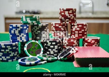 Jetons de poker - jetons de poker avec des cartes à jouer sur une table verte dans un close up Banque D'Images