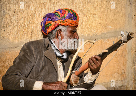 Homme jouant d'un instrument de musique à l'extérieur de l'Inde Rajasthan Patwa Haveli Jaisalmer Banque D'Images