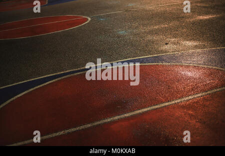 Des lignes et des couleurs sur l'asphalte de basket-ball par nuit. Banque D'Images