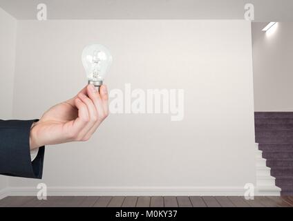 Hand holding Light bulb in room Banque D'Images