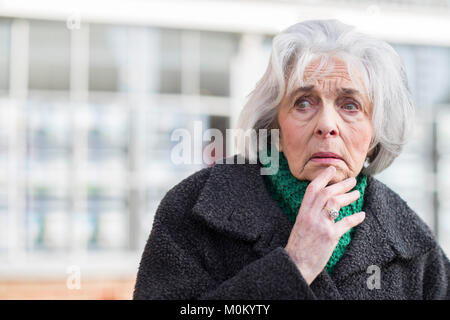 Inquiets Senior Woman Looking a perdu à l'extérieur Banque D'Images