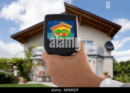 Close-up of personne détectant la perte de chaleur à l'extérieur chambre à l'aide de la caméra thermique infrarouge Banque D'Images