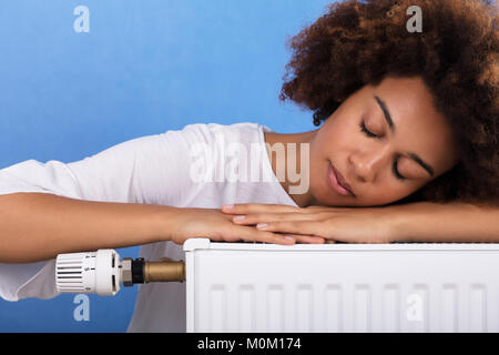 Close-up of a young woman dormir sur le radiateur de chauffage Banque D'Images