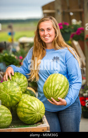 Young smiling woman pose avec des pastèques dans la main tout en s'appuyant sur une pile d'autres pastèques, Salisbury, Maryland Banque D'Images