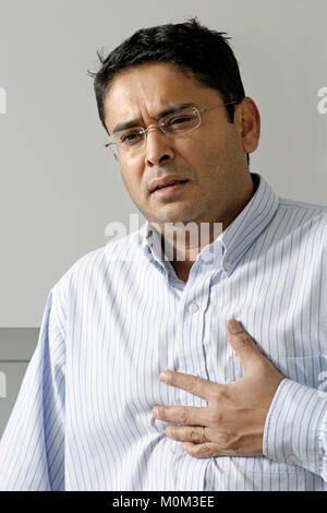 Photo d'un homme dans la fin des années 30 ayant une dose d'estomac ou des douleurs dans la poitrine. Banque D'Images