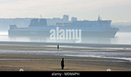 Une légère brume s'élève de la mer comme le Mersey ferry de Liverpool à Dublin passe Antony Gormley a un autre lieu à Crosby le Merseyside. Banque D'Images