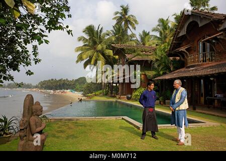 L'Inde, Goa, Coco beach,Richard Holkar,fils du maharadjah d'Indore, en face de son hôtel de luxe Ahilya par la mer avec sa piscine, les pêcheurs en face d'une plage bordée de cocotiers Banque D'Images