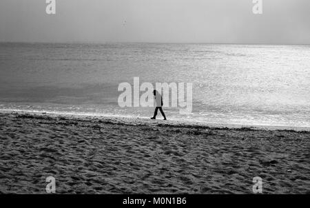 Un touriste se promène le long de la plage de Towan, près de Portscatho sur la péninsule de Roseland, à Cornwall, Angleterre, le 29 décembre 2017 Banque D'Images