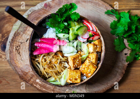 Bol avec du tofu soyeux Vegan, germes de haricots et légumes marinés sur du riz Banque D'Images