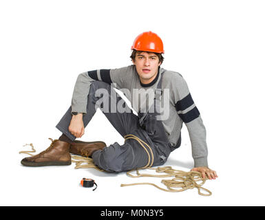 Un jeune travailleur dans l'uniforme gris attaché avec une corde blanche sur fond isolé. Banque D'Images