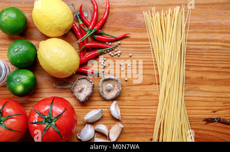 Ingrédients pâtes sur table en bois dans la cuisine, de l'ail,tomate,spaghetti aux champignons,achat,de citron, poivre, piment Banque D'Images