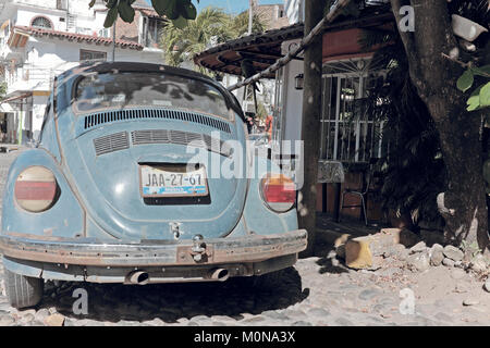 Une coccinelle Volkswagen est stationnée sur une route pavée à l'extérieur d'un restaurant local dans le quartier de la vieille ville de Puerto Vallarta, Mexique Banque D'Images