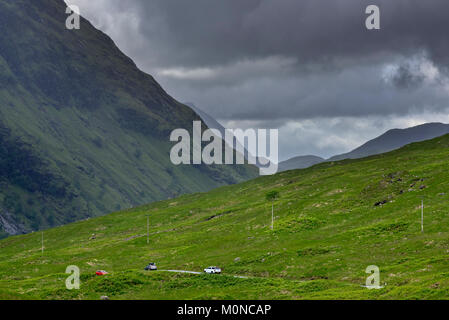 Passage de voitures sur route sinueuse au lieu de passage dans la désolation du paysage des Highlands à Glen Etive près de Glencoe dans les Highlands, Ecosse, Royaume-Uni Banque D'Images