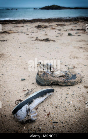 Deux morceaux de tatty lavé de chaussures à partir de la mer ou éliminé, allongé sur le sable de la plage de Porth Beach Nobla - Llanfaelog, Anglesey, Pays de Galles Banque D'Images