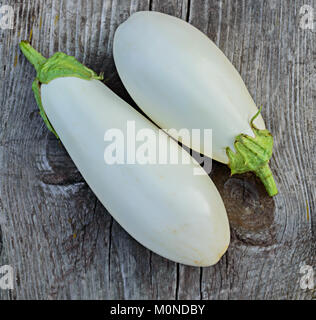 Deux aubergines blanches gros plan sur une vieille table en bois gris Banque D'Images