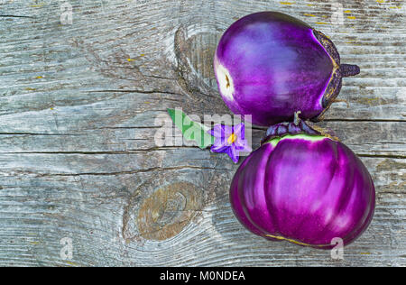 Gros plan sur deux aubergines violet une vieille table en bois gris Banque D'Images