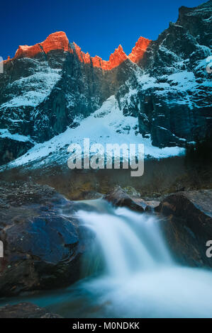 Début d'hiver matin alpenglow sur Trollveggen, ou le mur de Trollette, et les sommets Trolltindene dans la vallée de Romsdalen, Møre og Romsdal, Norvège. Banque D'Images