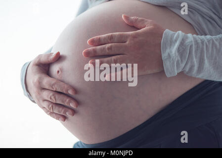 Le ventre de la femme enceinte, personne de sexe féminin dans le neuvième mois de grossesse posant Banque D'Images