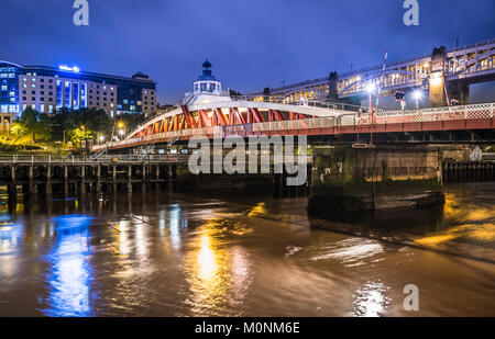 Photo de nuit du pont tournant de l'autre côté de la rivière Tyne, Newcastle-upon-Tyne, Tyne et Wear, Angleterre, avec le pont de haut niveau à l'arrière-plan. Banque D'Images