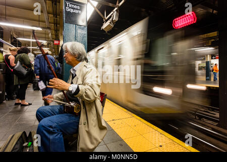 Musicien jouant de l'Asie dans l'erhu, métro Station, New York, NY, USA Banque D'Images