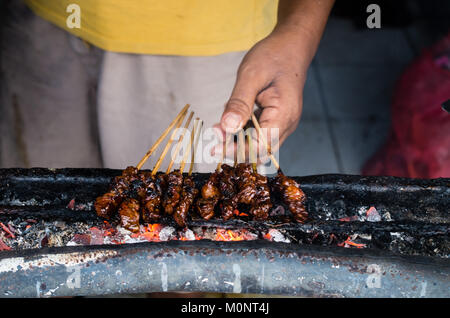 L'homme préparer sate ayam sur la rue du marché local à Bali, Indonésie Banque D'Images