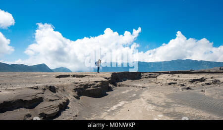 Jeune homme est debout à une masse splinter et photographié,volcan fumant Gunung bromo,Mt. Batok,Mt. Kursi,Mt. Gunung Banque D'Images