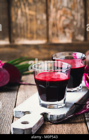 Produits frais bio jus de betteraves rouges et légumes frais sur une table en bois rustique Banque D'Images