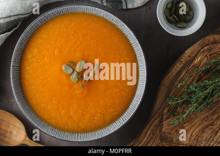 Vue de dessus de la soupe de potiron dans la plaque en céramique gris. Banque D'Images