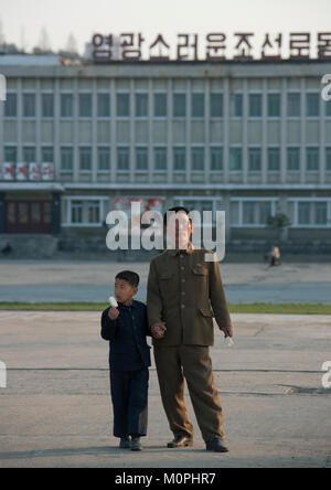 Père et fils nord-coréen de manger une glace dans la place principale, la province du Kangwon, Wonsan, la Corée du Nord Banque D'Images