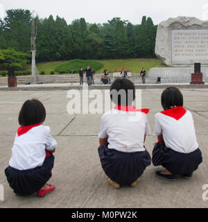 Pionniers de la Corée du Nord de l'écoute d'un groupe jouant de la musique sur la journée dans la rue, de la province de Pyongan, Pyongyang, Corée du Nord Banque D'Images