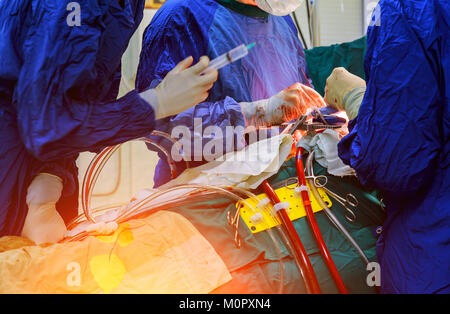 Les mains sont chirurgien faisant un nœud au cours de la procédure à coeur ouvert poitrine en chirurgie cardiaque Banque D'Images