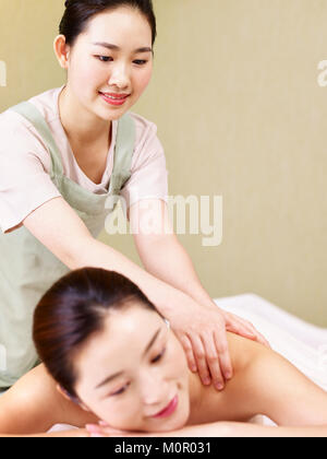 Masseur massage asiatique jeunes effectuant sur femme dans spa salon. Banque D'Images