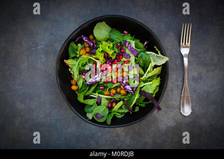 Bol de salade mixte avec des graines de grenade, le chou rouge et les pois chiches curcuma rôti Banque D'Images