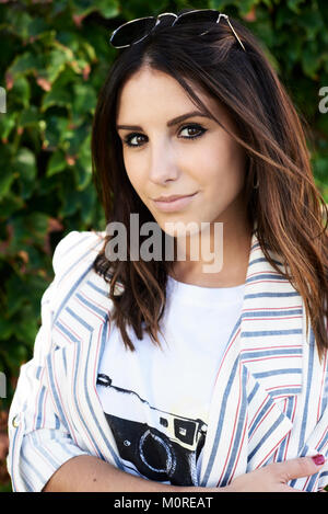 Portrait en extérieur d'une belle brunette millénaire girl looking at camera. Banque D'Images