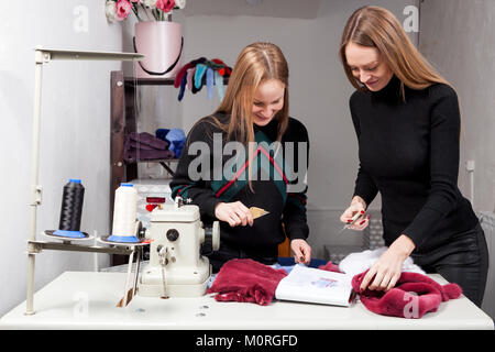 Deux jeunes femmes fourreurs discutons comment bien couper la fourrure naturelle de faire une femme de manteau de fourrure. Le processus de création d'un manteau de fourrure femme Banque D'Images